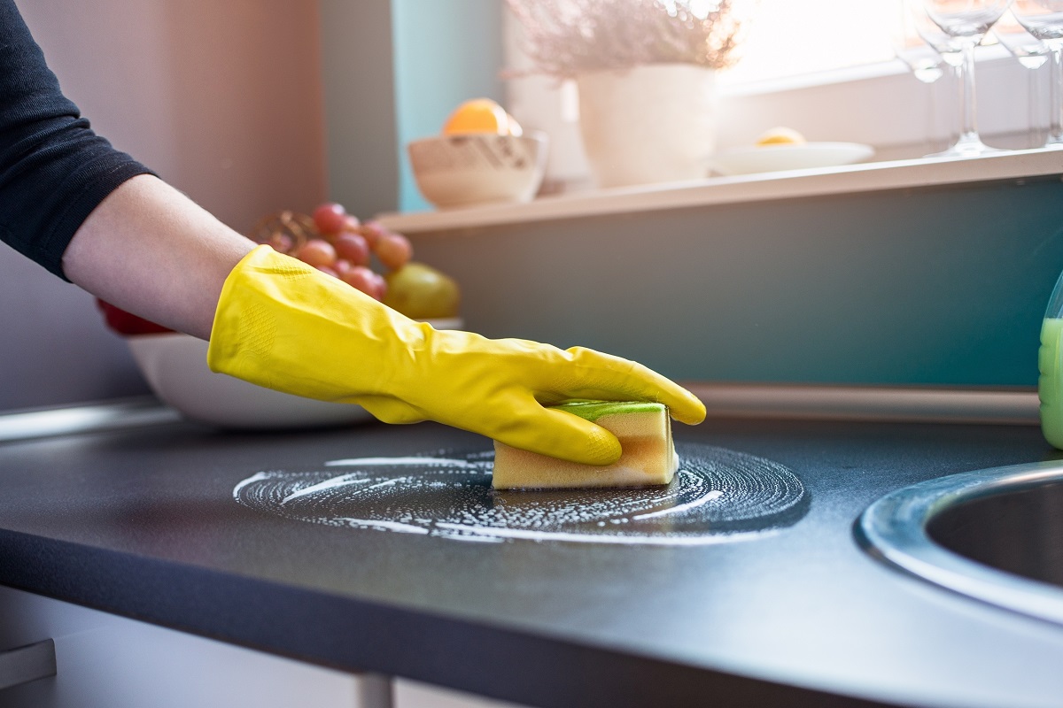 gloved hand cleaning countertop