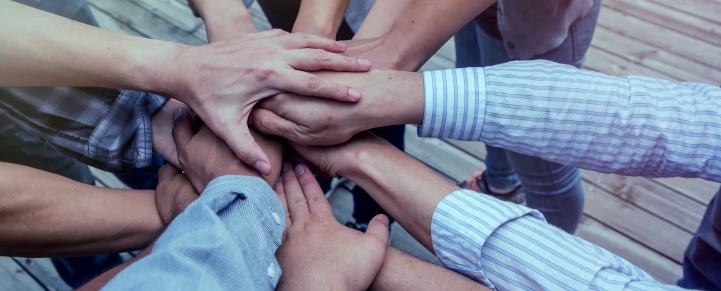 Group reaching hands in to the center