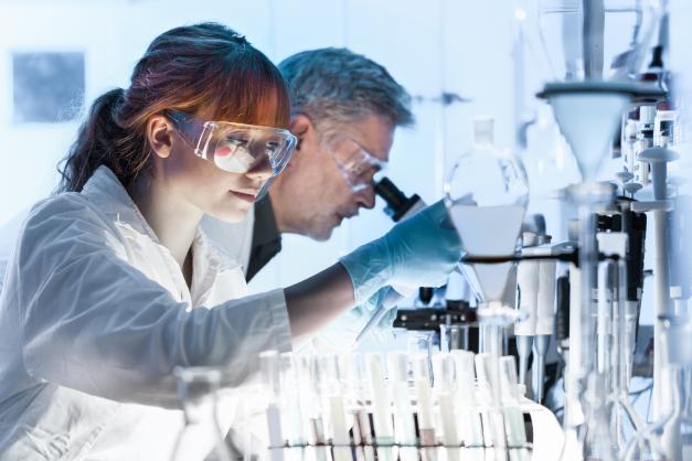 Female scientist looking into microscope