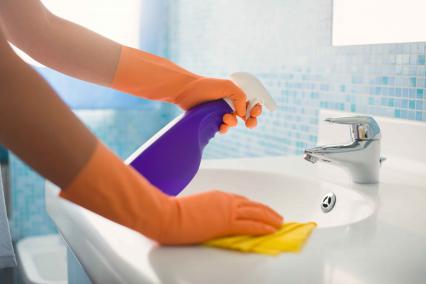 Spraying and wiping down a bathroom counter top